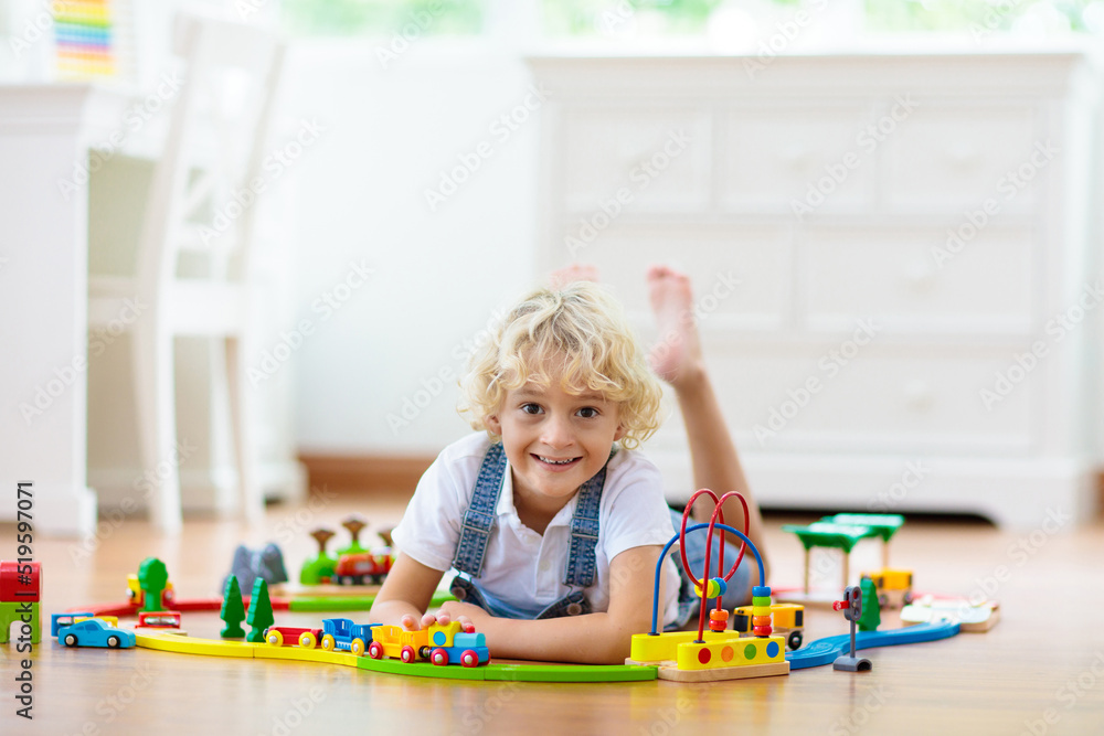Kids play wooden railway. Child with toy train. Kids play wooden railway. Child with toy train.