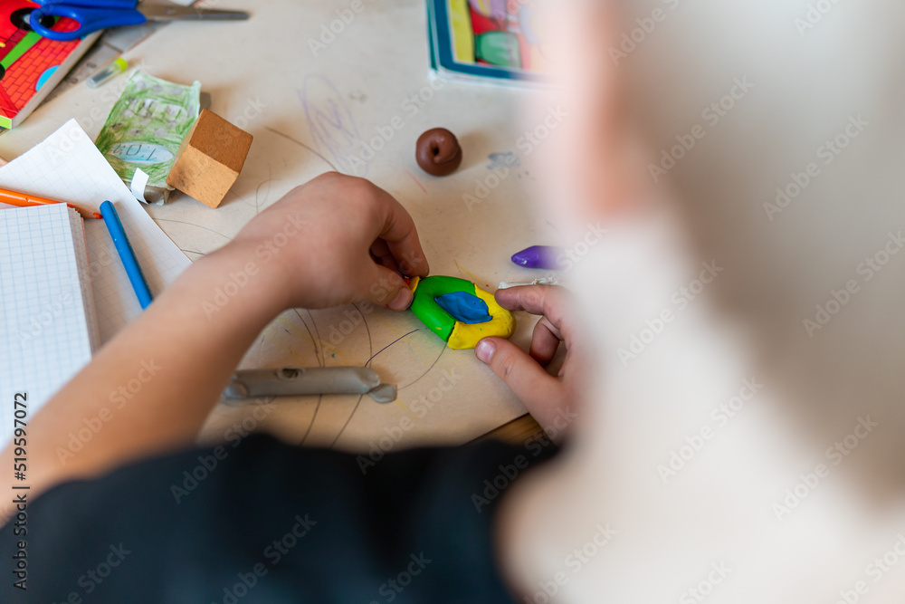 Naklejka premium Poland, Krakow – April 03, 2022: Child is sculpting a figure from plasticine at the table