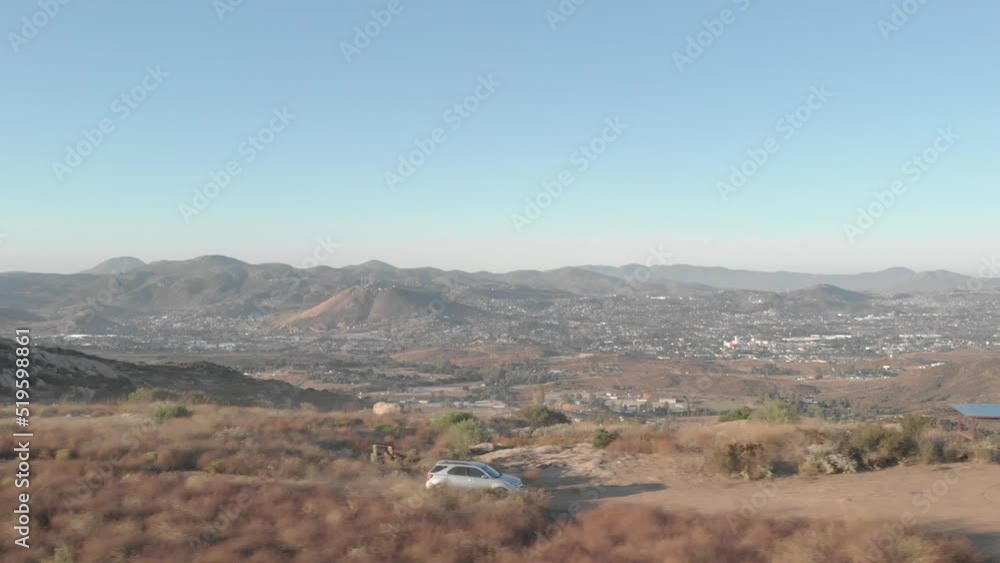 Car driving along mountain roads drone shot, with beautiful scenery of mountains and skyline in the background Car driving along mountain roads drone shot, with beautiful scenery of mountains and skyline in the background
