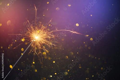 Happy New Year, Christmas Sparkler burning bright with shiny sparks and bokeh festive silvester party background