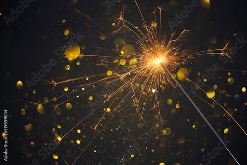 Fototapeta Happy New Year, Sparkler burning bright with shiny sparks and bokeh festive silv