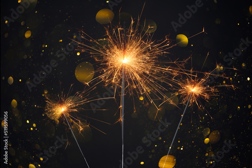 Happy New Year, Sparklers burning bright with shiny sparks and bokeh festive silvester party background