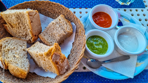 Sauces called Mojo rojo and mojo verde served with white bread in a local restaurant in Los Abrigos, Tenerife, Canary Islands, Spain, Europe, EU. Local traditional food. Appetiser photo