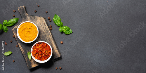 Assortment of aromatic herbs and spices on black rustic background with copy space for your design top view.