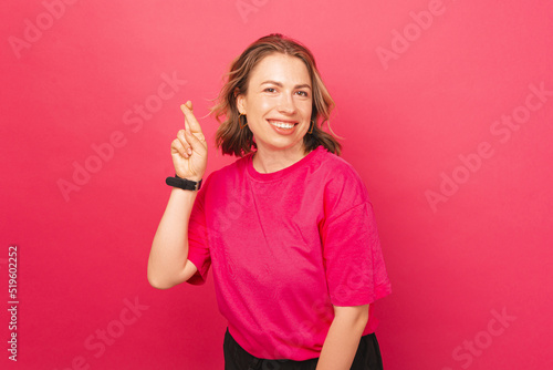 A piicture of a young woman holding her fingers crossed being positive and wshing for something photo