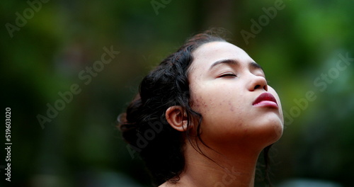 Contemplative young woman closing eyes in meditation. Close-up girl face eye closed