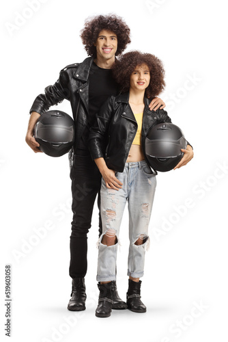 Full length portrait of a young man and woman in leather jackets holding motorbike helmets