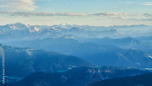 Landscape with distant mountains int the setting sun appearing blue with haze, looking toward the central alpine region from Austria toward Switzerland as seen from the Dachstein Mountains