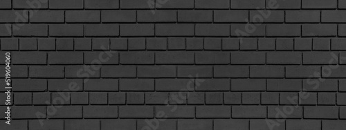 Old dark grey brick wall wide texture. Black exterior brickwork grunge background