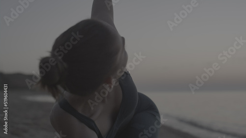 Yoga girl practicing triangl pose on beach close up. Woman training flexibility.