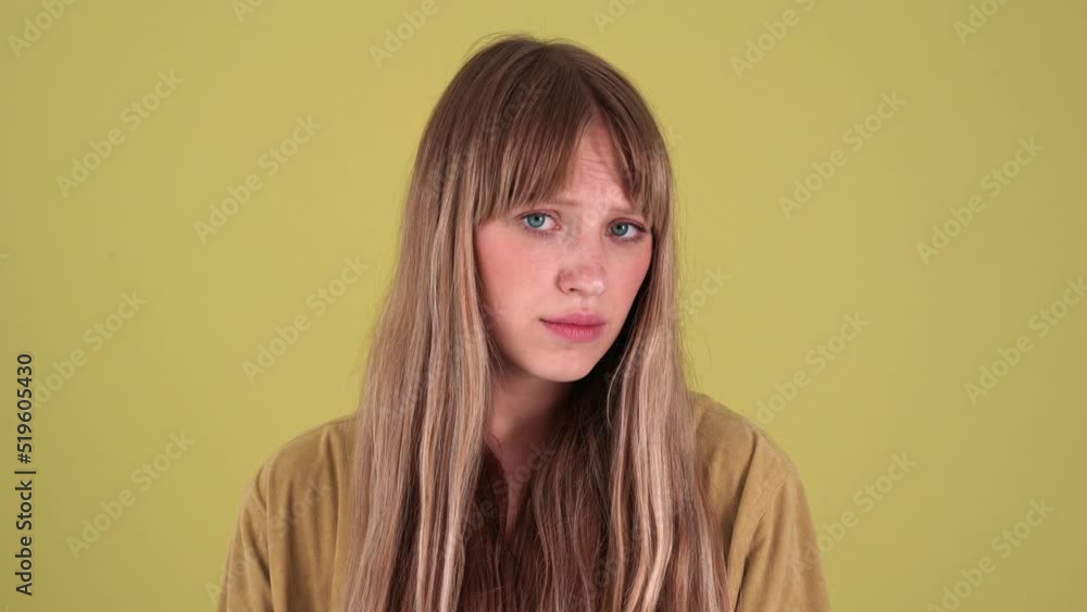 Offended blonde woman looking at the camera isolated over green background in studio Offended blonde woman looking at the camera isolated over green background in studio