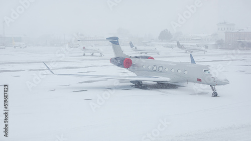 Snow covered commercial plane at the airport. Close-up of the plane after snowfall. Winter bad weather conditions.