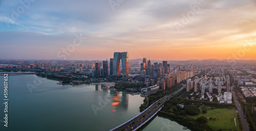 Aerial view of city skyline and modern commercial buildings in Suzhou at sunset, China.