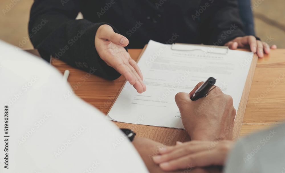 A lovely couple in the meeting with their real estate agent to sign the house contract. Property investment concept. cropped image A lovely couple in the meeting with their real estate agent to sign the house contract. Property investment concept. cropped image