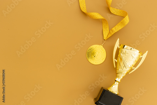 Winner and success background - gold medal and trophy cup, top view