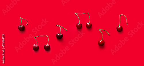 on red background notes from berries sweet cherry red color place inscription music notation camp copy space banner
