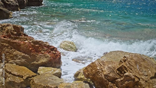 slow motion footage tropical island and sea waves crashing and foaming against rocky beach. golden rocks coast meeting deep blue ocean water. Tourism in Turkey concept photo