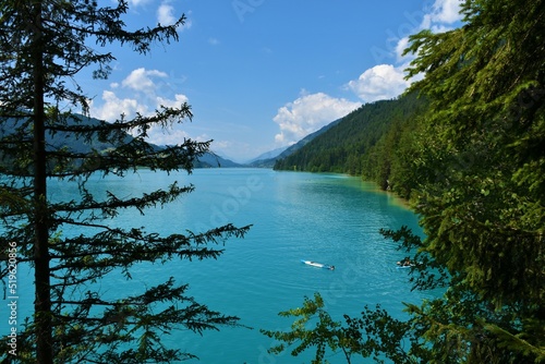 Scenic view of Weissensee lake in turuoise color with the coast covered in forest in Carinthia, Austria photo