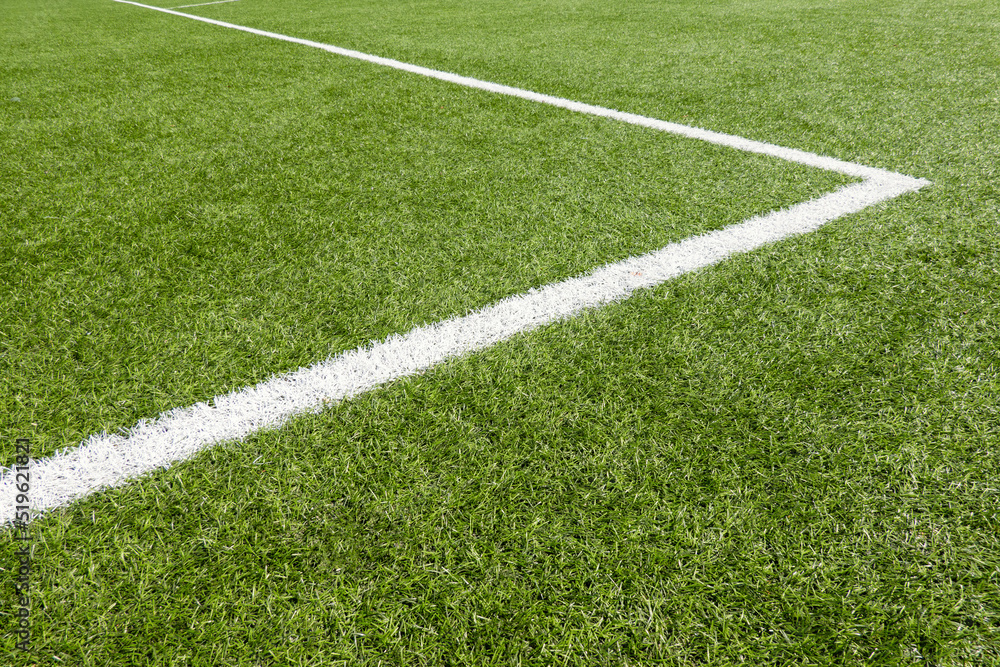 Obraz premium Green synthetic artificial grass soccer sports field with white corner stripe line
