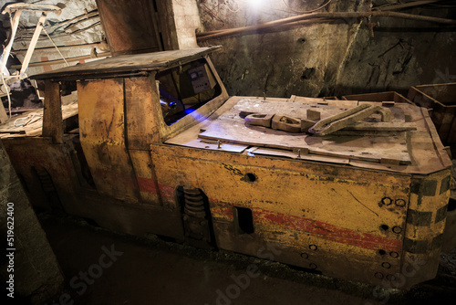 Dirty electric locomotive in the mine underground. Technologies of underground mining. Industrial equipment in the mine.