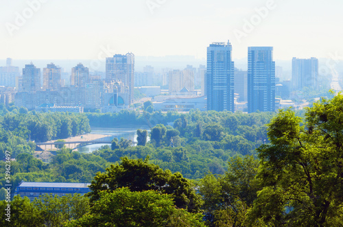 Aerial cityscape of Kyiv in morning haze. Silhouettes of modern high-rise buildings at smog. Concept of modern architecture from glass, steel and concrete. High-rise houses at morning smoke