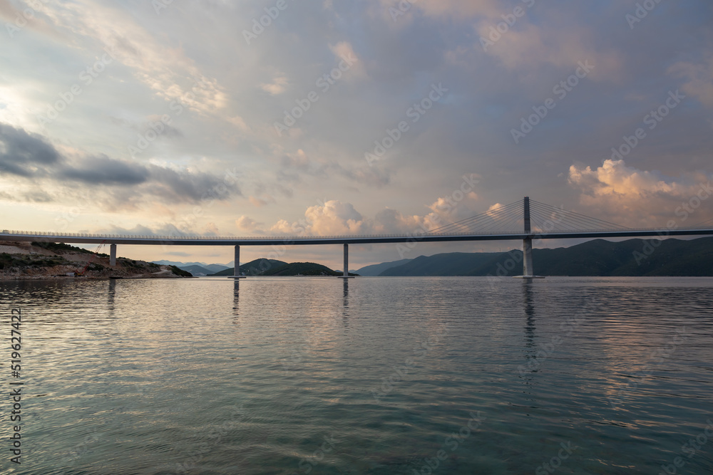 Beautiful bridge across the sea to Peljesac peninsula in Croatia. There are dramatic clouds in the sky.