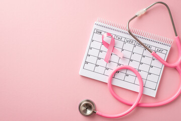 Top view photo of pink ribbon symbol of breast cancer awareness calendar and stethoscope on isolated pastel pink background with copyspace