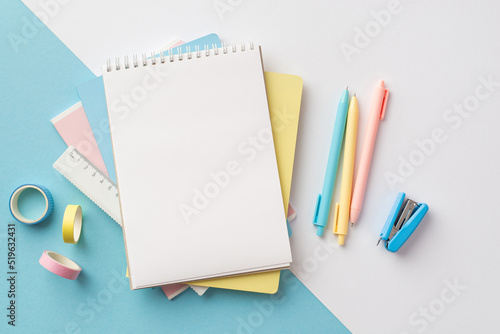 Back to school concept. Top view photo of school supplies stack of notepads pens ruler stapler and adhesive tape on bicolor blue and white background with copyspace