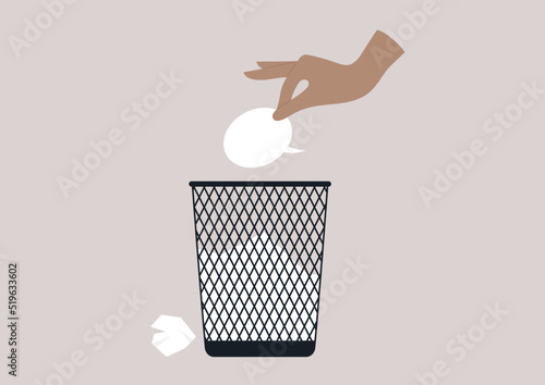 A hand throwing a speech bubble in a waste bin, a censorship concept