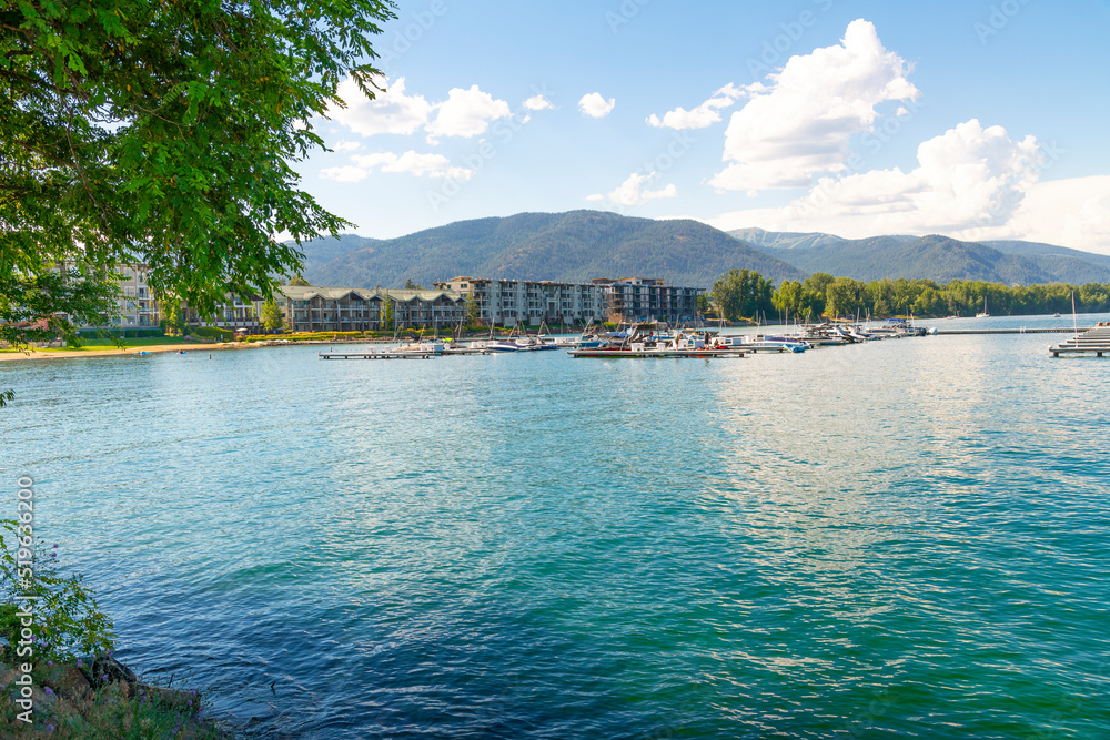 View from the Sandpoint City Beach Park of Lake Pend Oreille waterfront resorts and condominiums with marinas full of boats on a summer day in Sandpoint, Idaho.