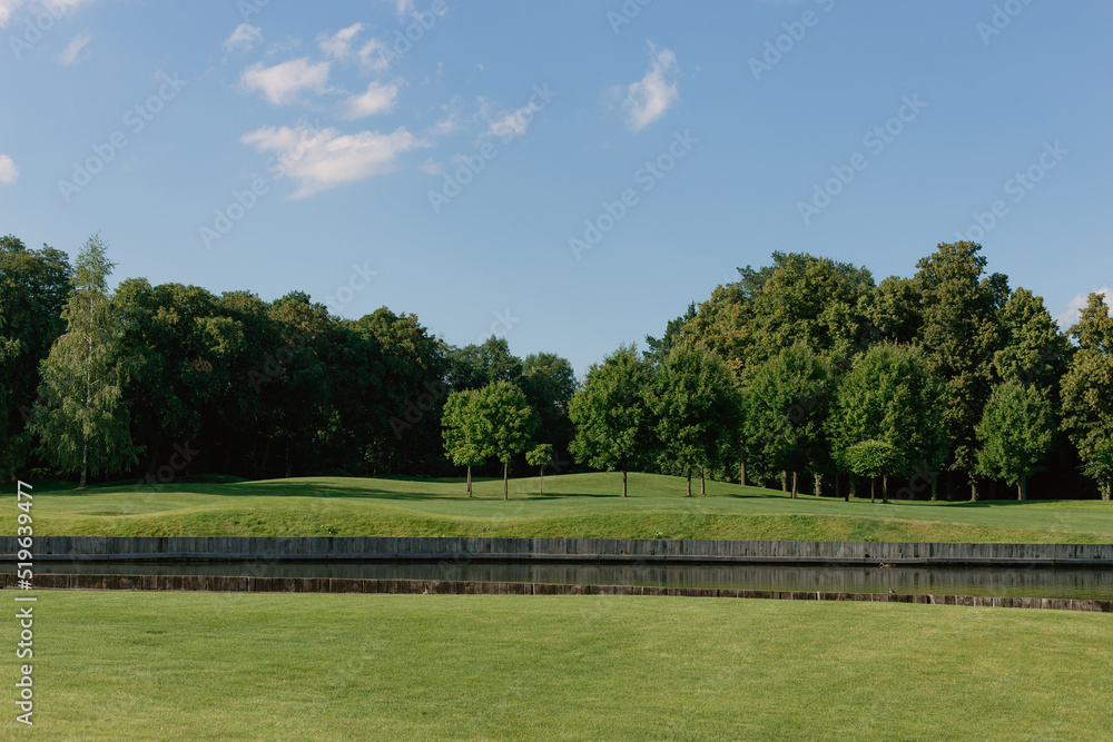 Beautiful sunny summer landscape with a green golf course 