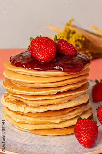 Pancakes with strawberry jam, whipped cream and strawberries