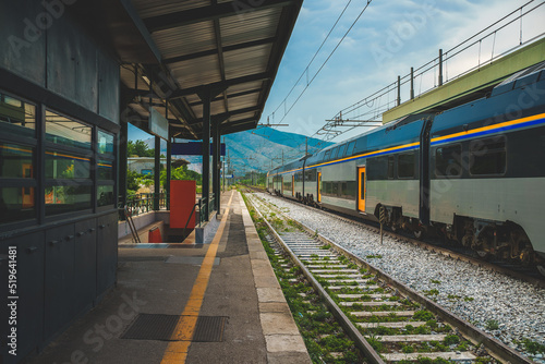 Double decker train passing by the train station in Italy.