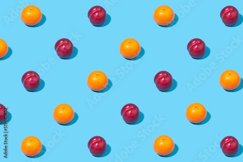 Creative pattern of ripe fruits arranged in even rows on a blue background