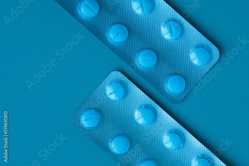 Pills on a blue bacground. Two blisters with tabletes are arranged diagonally.