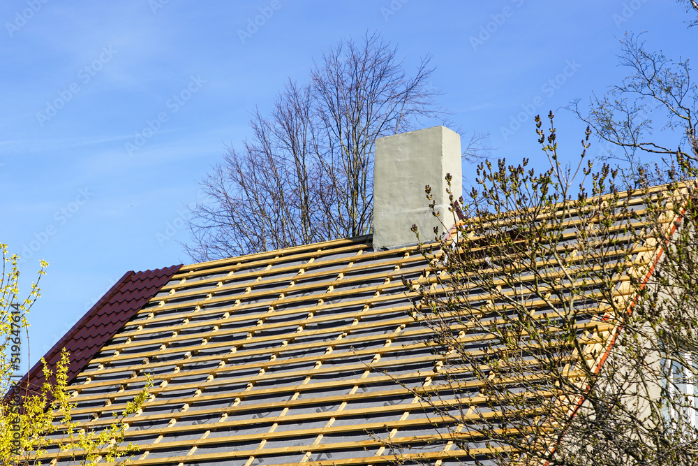 Replacement the roof covering of a small private house, half replaced, half not yet, metal roofing Replacement the roof covering of a small private house, half replaced, half not yet, metal roofing
