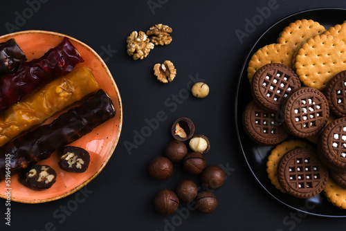 Churchkhela is a sweet delicacy of nuts in juices thickened with flour. Georgian churchkhela in a plate on a dark table with nuts. Close-up photo