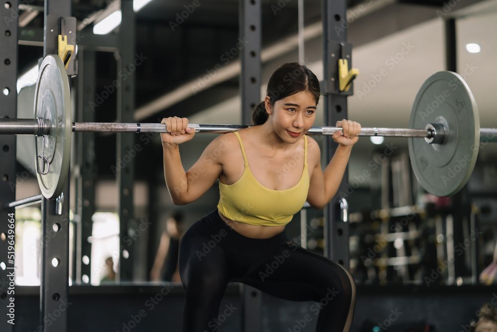 Beautiful Asian woman working out in the gym to stay fit and strong and gain beautiful muscles by lifting weights. Beautiful Asian woman working out in the gym to stay fit and strong and gain beautiful muscles by lifting weights.