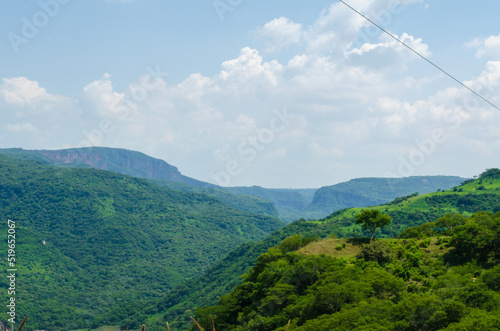 Carretera a Saltillo en la Sierra Madre Occidental, paisaje verde con un cielo azul con grandes nubes