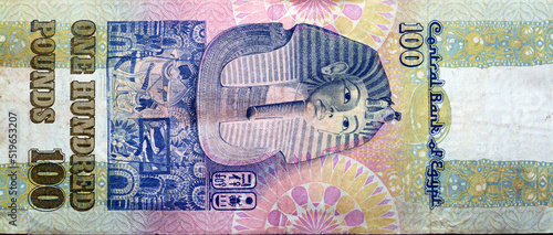 Large fragment of reverse side of an old 100 LE EGP one hundred Egyptian cash money banknote Tutankhamen's mask above frieze at centre of vertical format, selective focus of withdrawn Egyptian Pounds photo