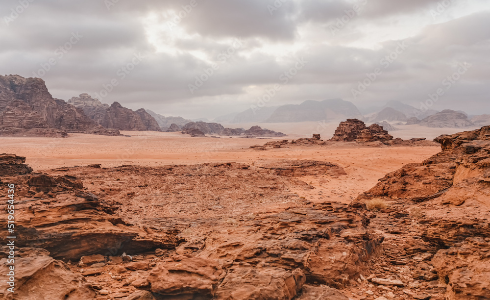 Fototapeta premium Red orange Mars like landscape in Jordan Wadi Rum desert, mountains background, overcast morning. This location was used as set for many science fiction movies