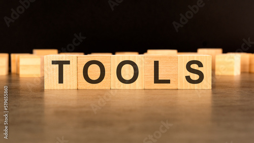 word TOOLS written on wooden cube block stack on black background, business concept