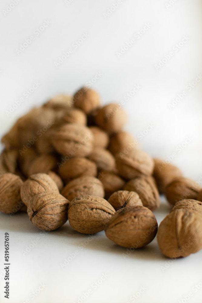 Walnuts scattered on the table on a light background Walnuts scattered on the table on a light background