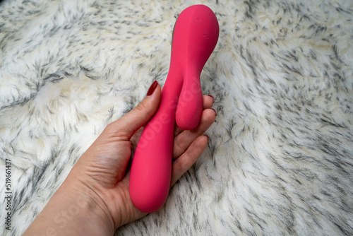 woman hand holding pink vibrator rabbit 
