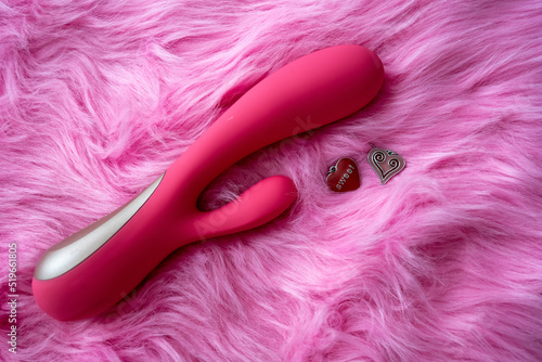 pink vibrator sex toy with hearts on pink background photo