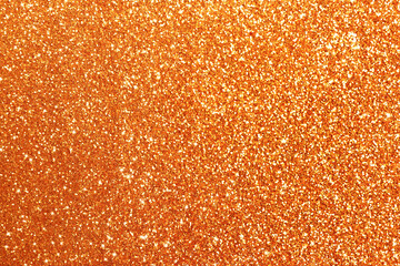 Beautiful shiny orange glitter as background, closeup