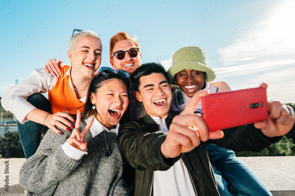 Group of multi-ethnic young friends taking a picture together with a smartphone. - obrazy, fototapety, plakaty 