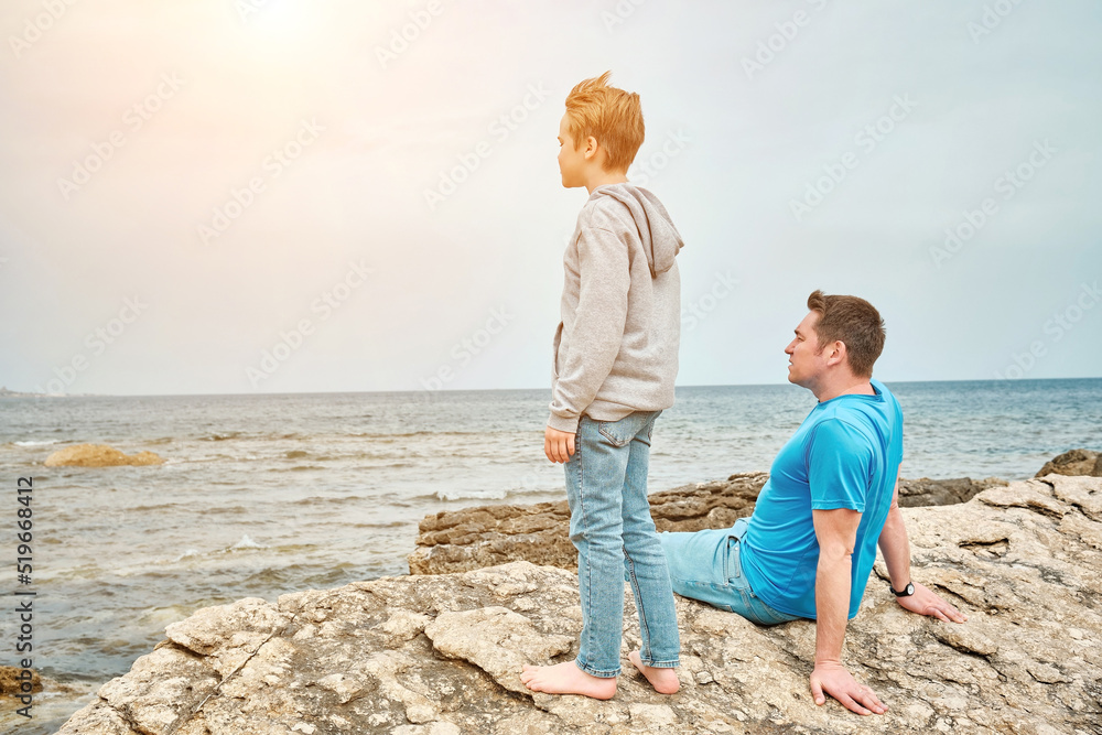 Happy family, father and son bonding, sitting on stone by the sea looking at view enjoying summer vacation. Togetherness Friendly concept
Happy family, father and son bonding, sitting on stone by the sea looking at view enjoying summer vacation. Togetherness Friendly concept