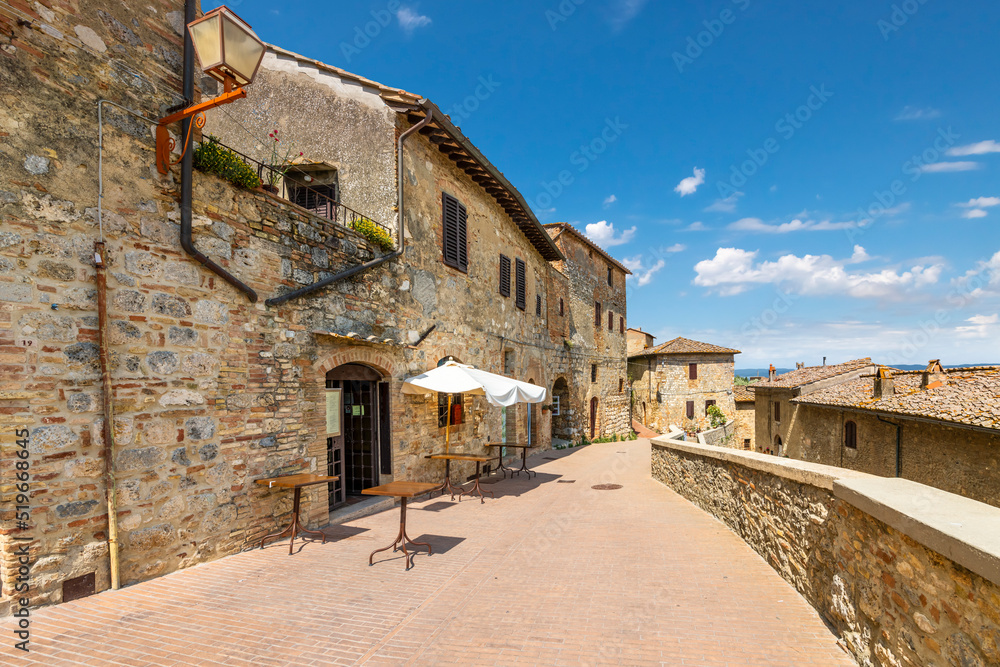A terrace with cafe and tables on the outer wall of the hill town of San Gimignano, in the Tuscany region of Italy.