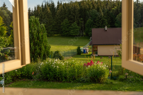 view through an old weathered vintage window to a picturesque green garden somewhere in the mountains, countryside, vivid colors, Slovakia, Europe